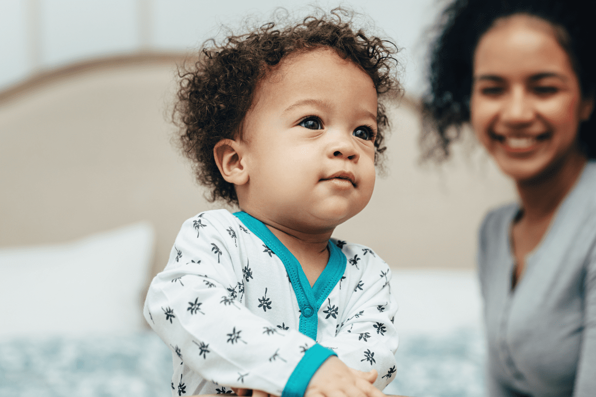 mom smiles behind baby