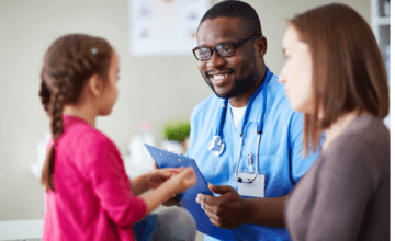 Male clinician speaks to child and mother