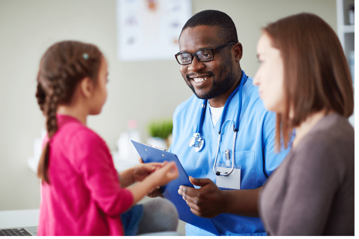 Male clinician speaks to child and mother