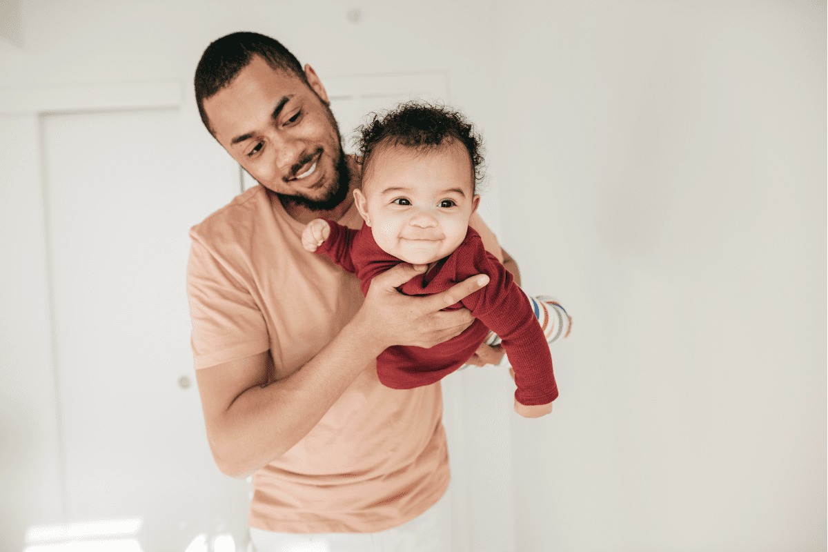 Dad holds baby likes superman