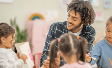 childcare man smiling at kid's drawing