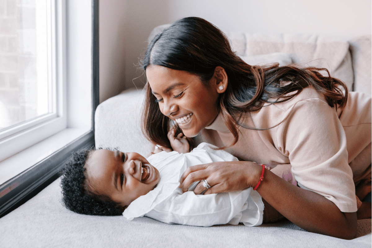 mom tickling baby laughing