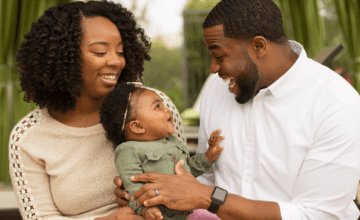 parents laughing with child, black family