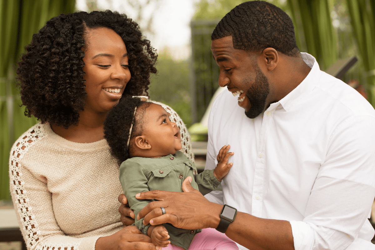 parents laughing with child, black family