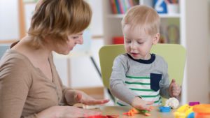 Woman playing with blocks with a toddle