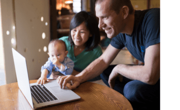 parents smiling with baby on laptop