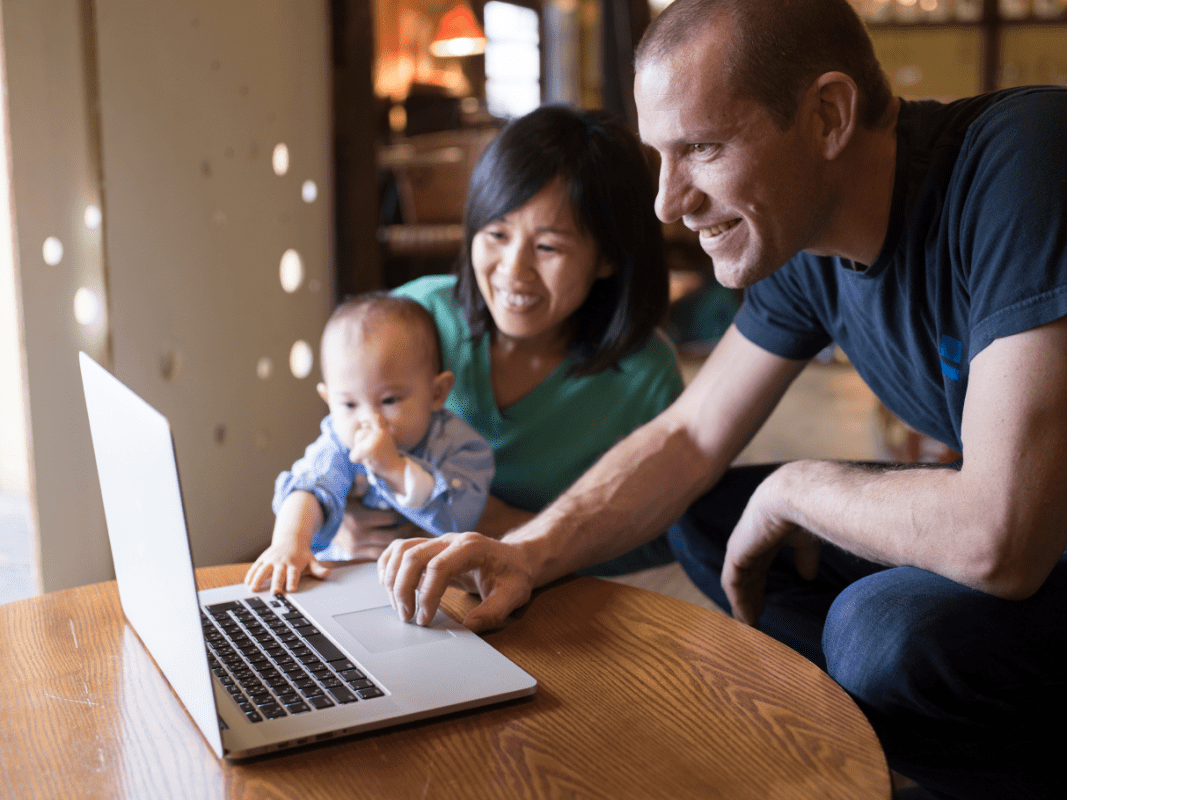 parents smiling with baby on laptop