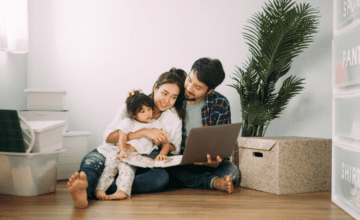 parents and child sit on floor with laptop