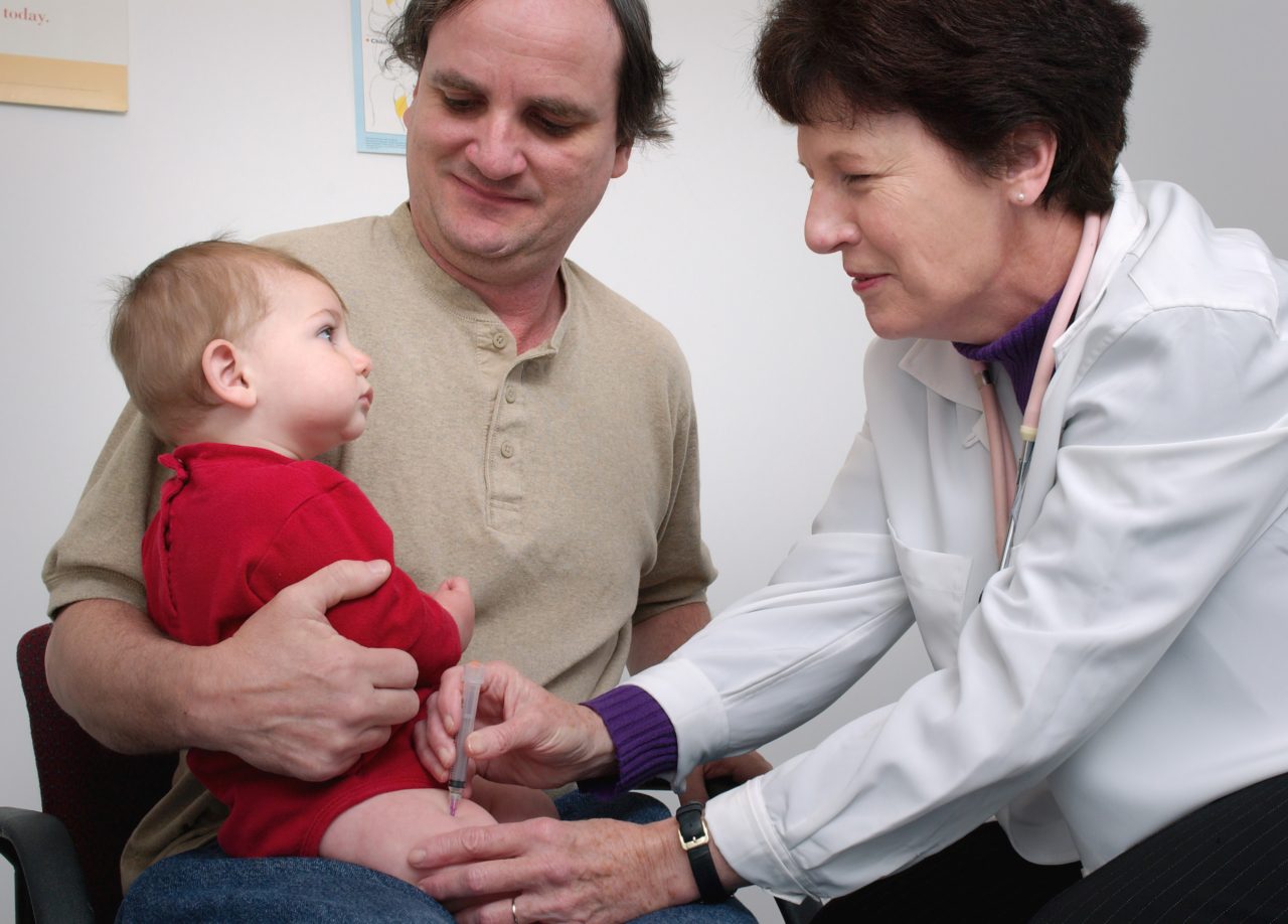 boy in red getting a vaccine