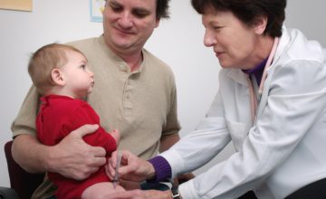 boy in red getting a vaccine