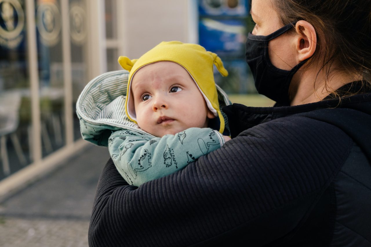 mom with mask holding baby