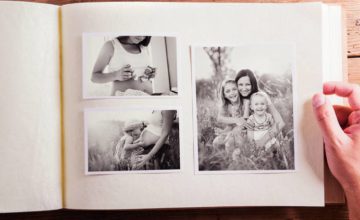 Black and white pictures in a photo album, two children and adult woman and a pregnant woman with a cjild kissing her stomach and a pregnant woman's mid torso