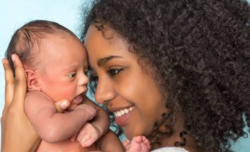 Womnan holding infant to her face