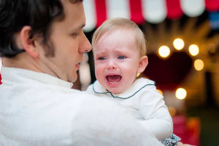 Man carrying crying infant