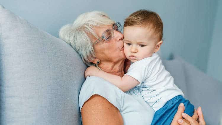 Grandma holding and kissinginfant