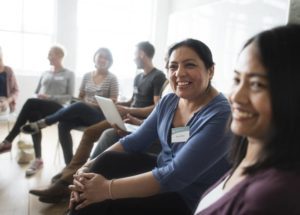 Smiling women in a row of sitting people