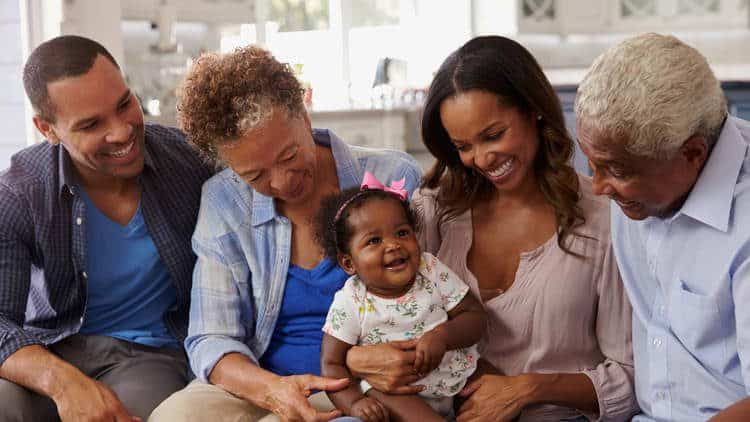 Young couple, elderly couple and smiling infant girl