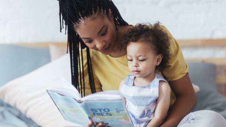 Mother reading a book to their toddler