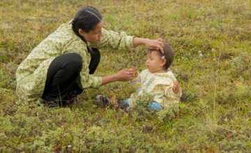 Mother and baby in a field playing