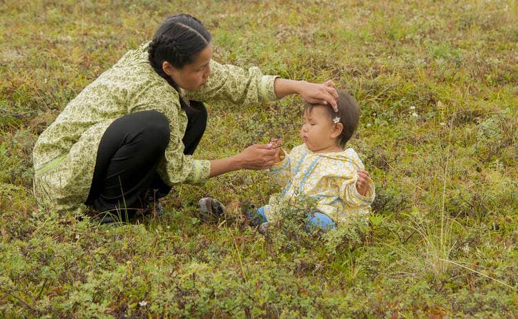 Mother and baby in a field playing