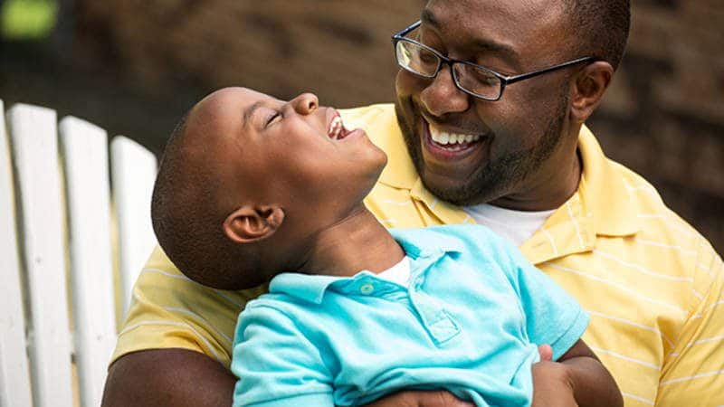 Dad looking at child and laughing together