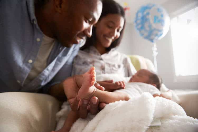 Parents looking over baby and smiling