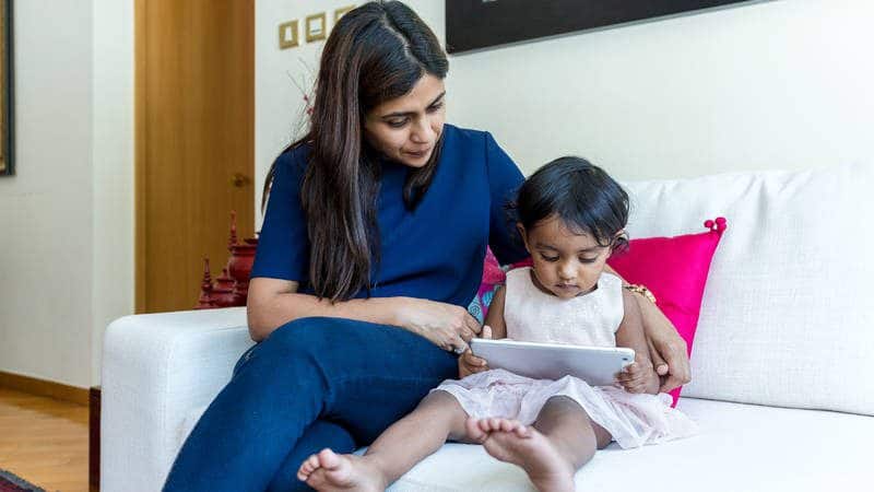 Mother Helping Child Hold a Tablet