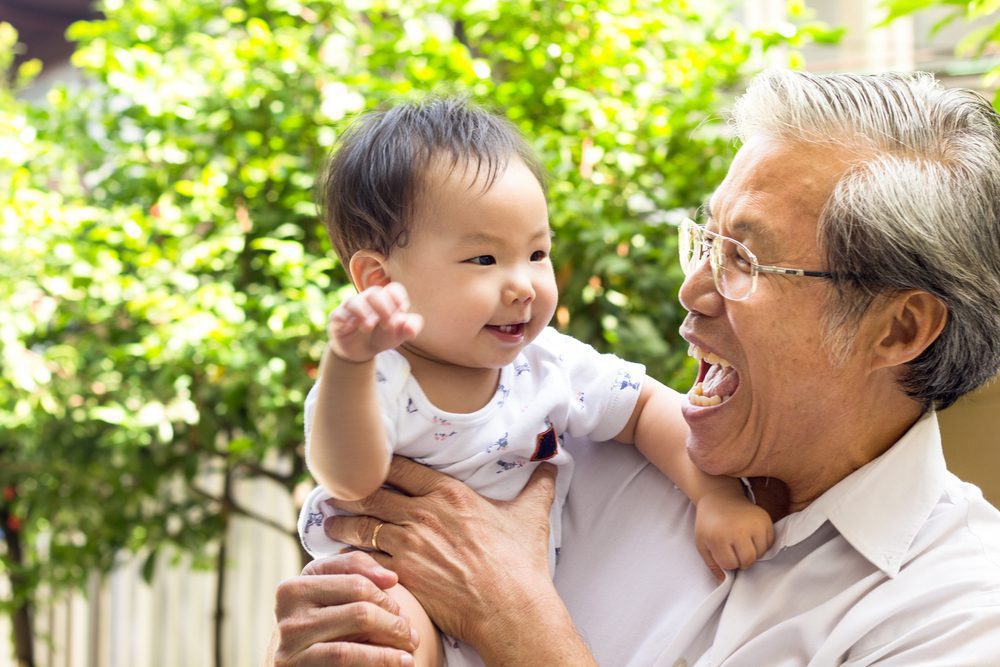 grandfather holding grandson playing and laughing