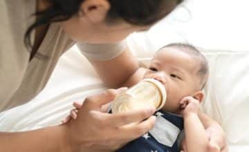 Parent feeding baby with a bottle