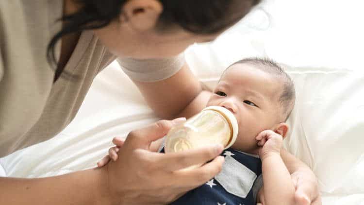 Parent feeding baby with a bottle