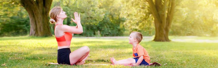 Mother and son doing yoga in the park