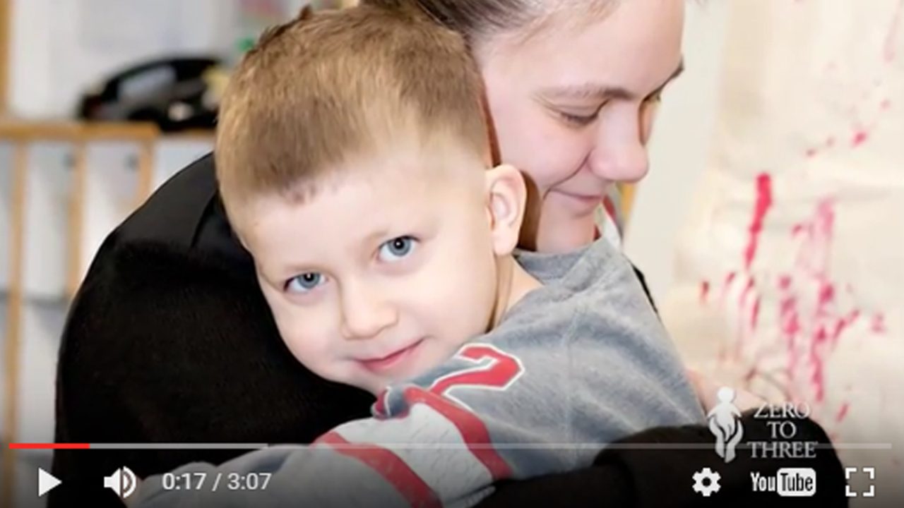 video still of woman holding small child