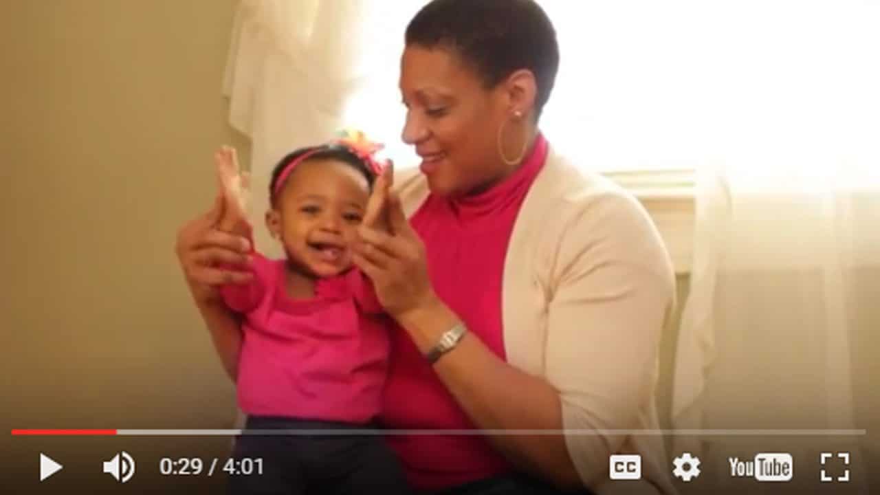 video still of woman on couch playing with small child