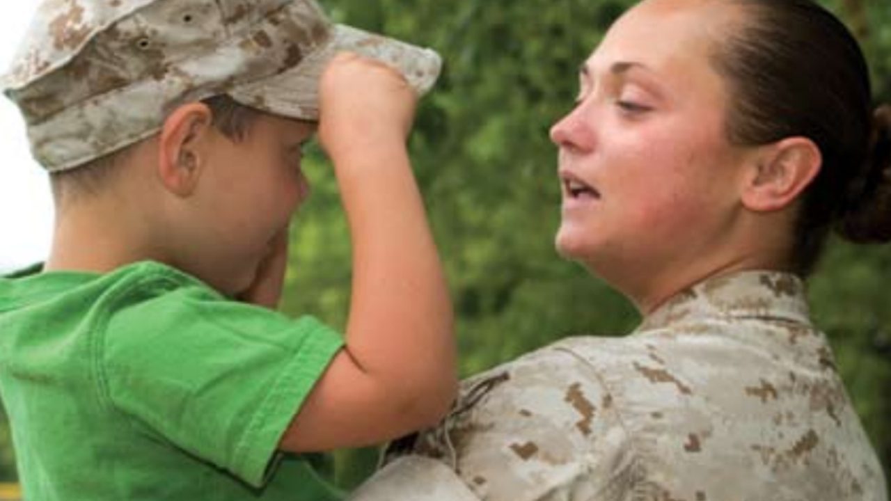 military mom holds son as he wears her hat
