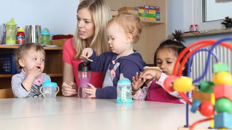 Adult playing with babies and toddlers