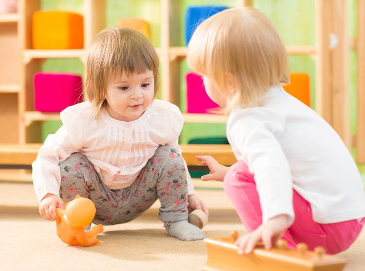 two young toddlers playing in classroom