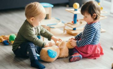 Toddlers playing with toys on the floor