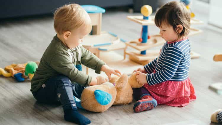 Toddlers playing with toys on the floor