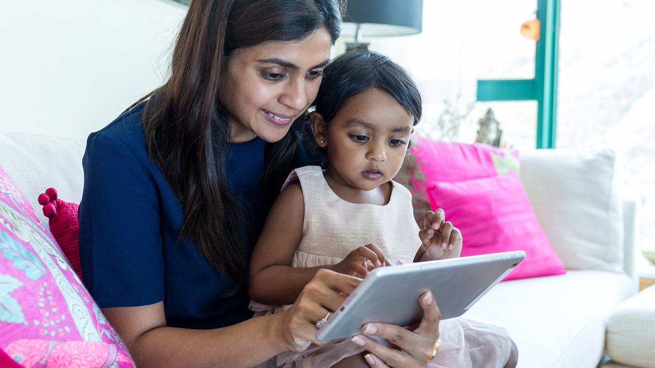 grandmother playing with child on tablet