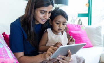 grandmother playing with child on tablet