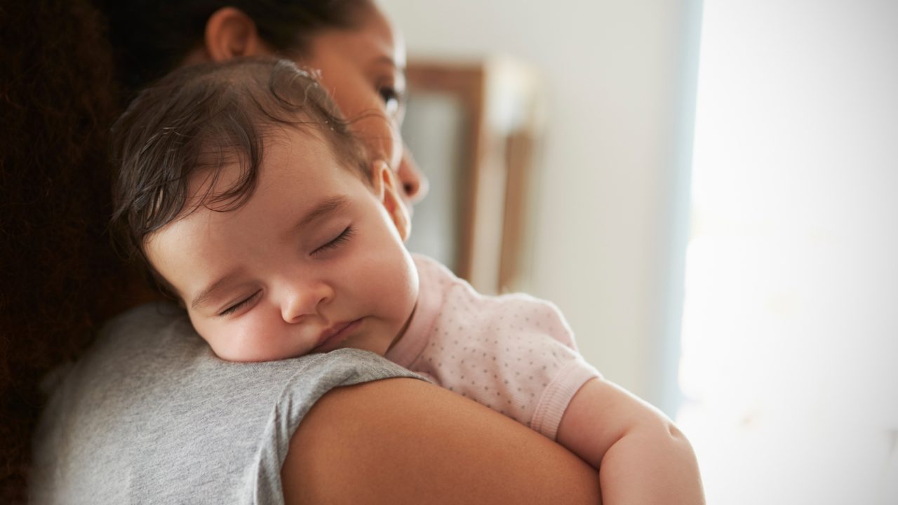 baby sleeping on woman's shoulder