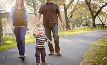 Parents with walking toddler at the park