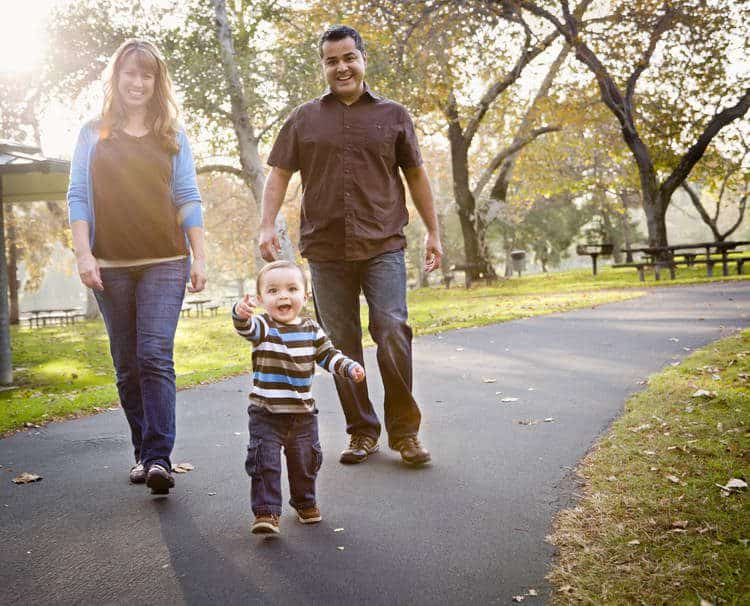 Parents with walking toddler at the park