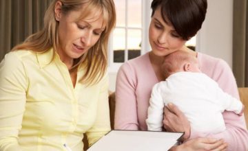 Professional helping mother with baby