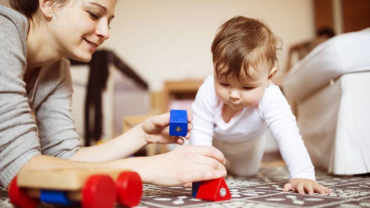 Parent playing with baby on the floor