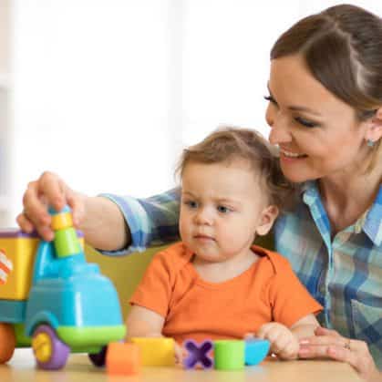 Parent playing with baby and a toy truck