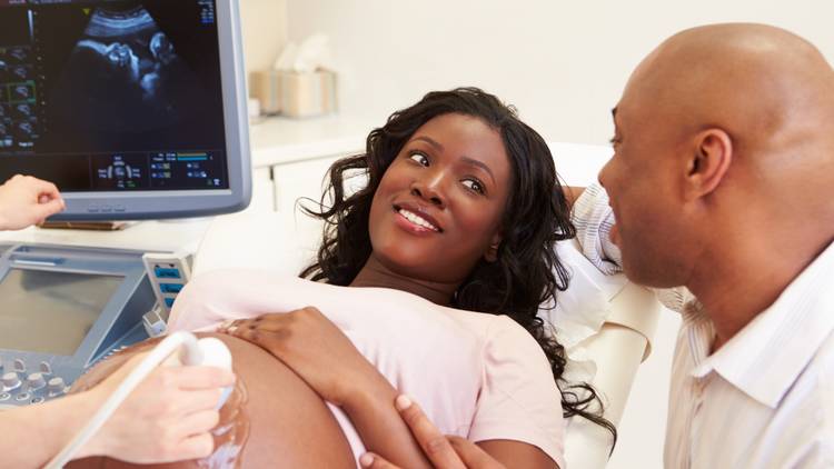 Pregnant mother with father at the doctor with a ultrasound