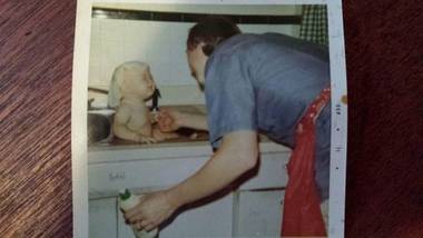 dad washing baby in kitchen sink