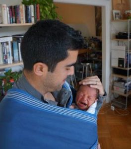 father holding newborn in body wrap
