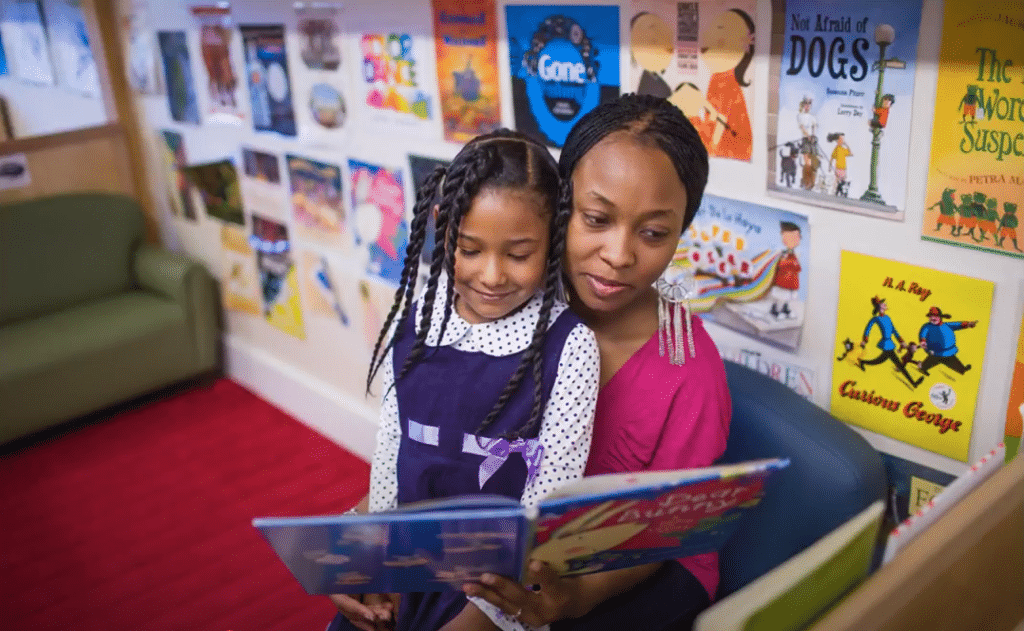 Child Care Provider Reading Book to Toddler